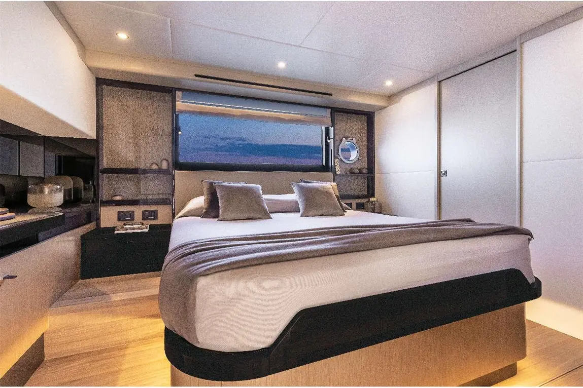 Modern bedroom with a double bed, two pillows, a large window, and elegant furnishings, creating a serene atmosphere.